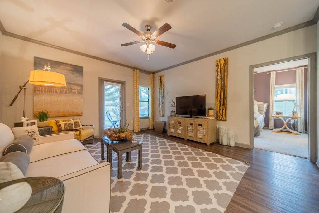 a living room filled with furniture and a ceiling fan